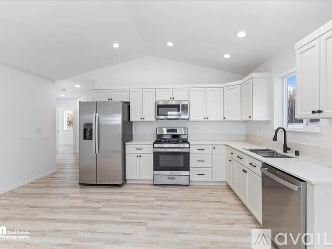 A modern kitchen with stainless steel appliances and white cabinets.