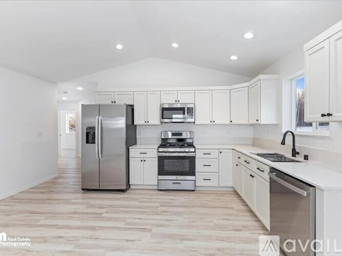 A modern kitchen with stainless steel appliances and white cabinets.