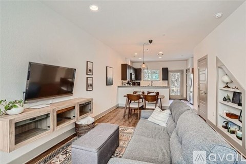 A living room with a grey couch and a wooden entertainment center.