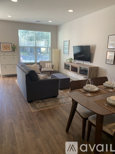 A living room with a couch, a chair, a table, and a television.