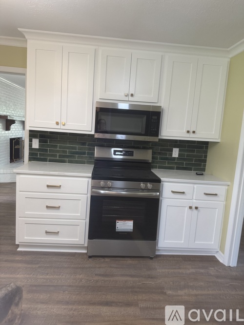 A kitchen with white cabinets and a black oven.