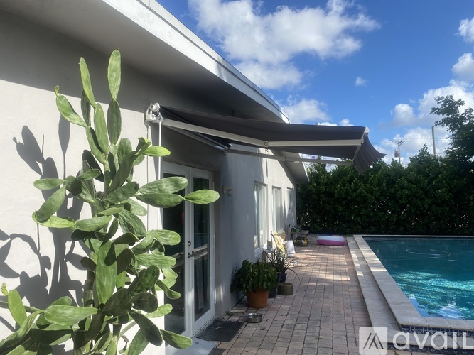 A house with a pool and a cactus in front.