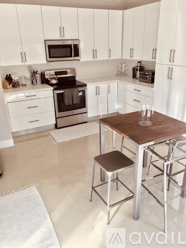 A kitchen with white cabinets and a wooden table.