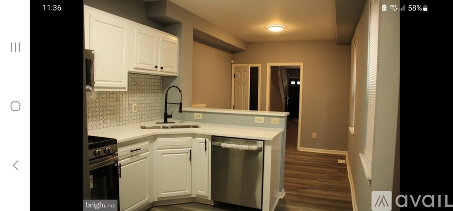 A kitchen with white cabinets and a dishwasher.