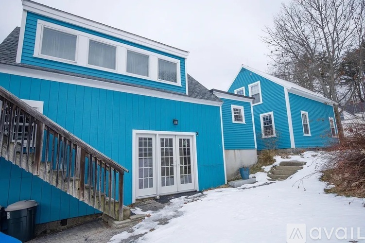 A blue house with a white door and windows.