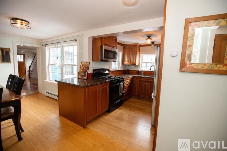 A kitchen with wooden cabinets and a black stove top oven.