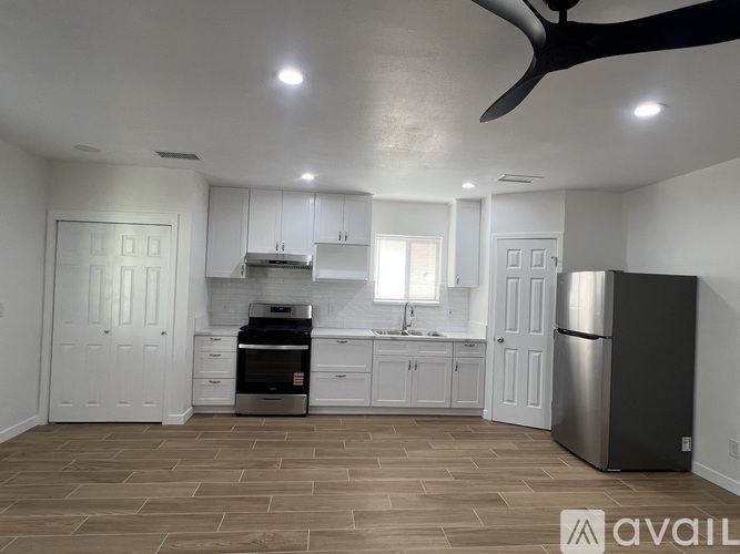 A kitchen with a refrigerator, oven, and sink.