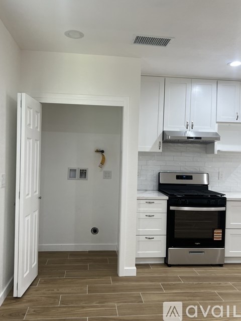 A kitchen with white cabinets and a stainless steel oven.