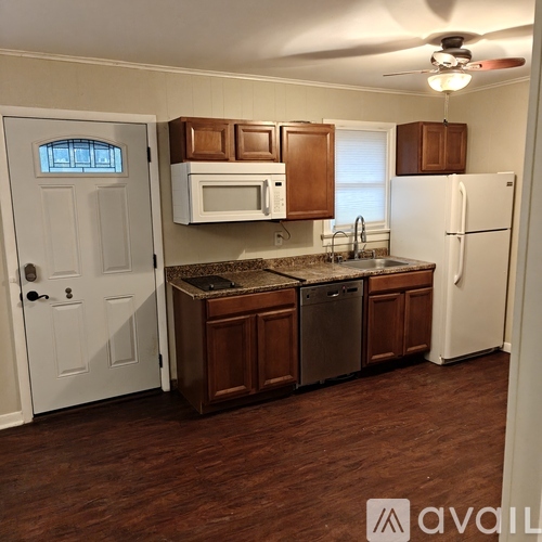 A kitchen with white appliances and wooden cabinets.
