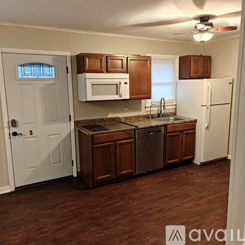 A kitchen with white appliances and wooden cabinets.