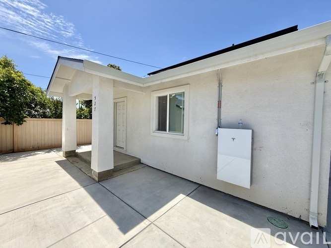 A house with a white exterior and a covered patio area.