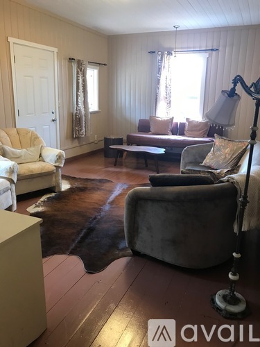 A living room with a cowhide rug and a white chair.