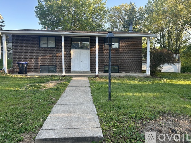 A brick house with a white door and a walkway leading to it.
