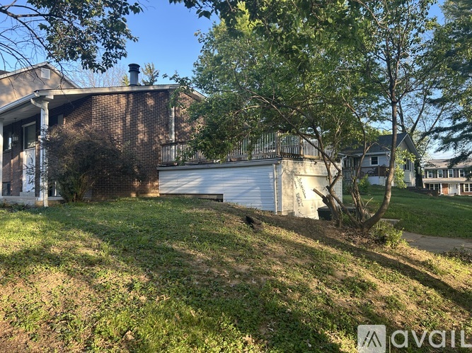 A house with a white garage door and a tree in front.