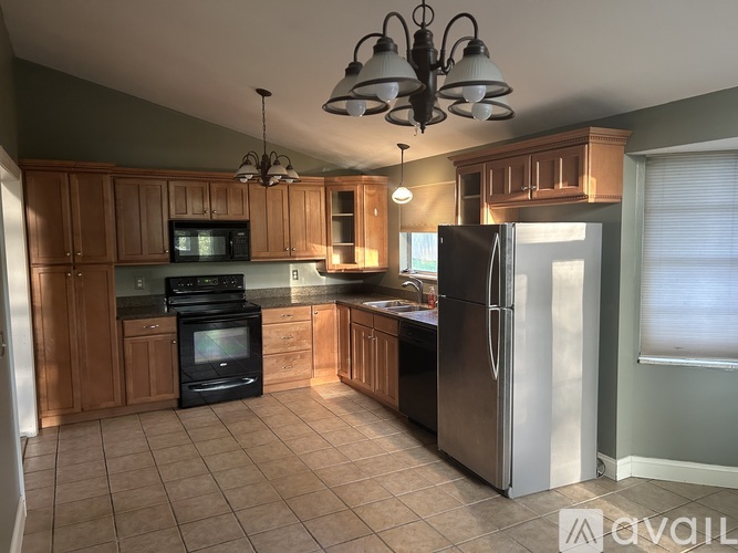 A kitchen with a black refrigerator and a black stove.