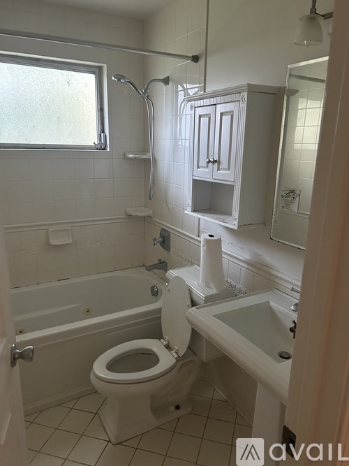 A white bathroom with a toilet, sink, and bathtub.