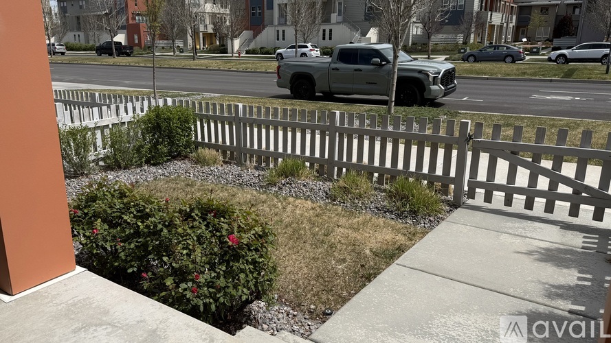 A white picket fence with a small garden in front of a building.
