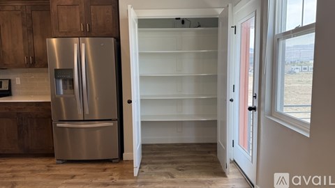 A kitchen with a stainless steel refrigerator and wooden cabinets.