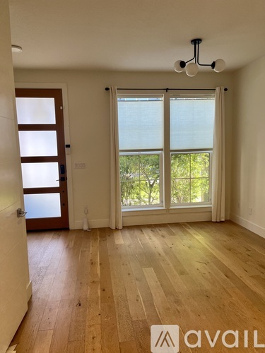A room with wooden flooring and a sliding glass door leading to a balcony.