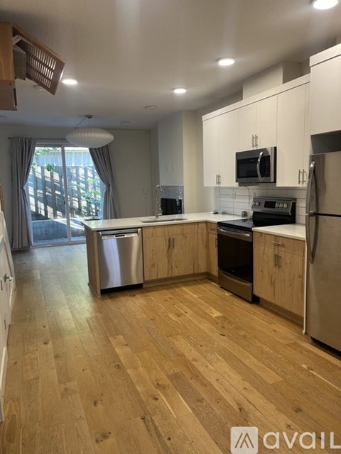 A kitchen with wooden floors and stainless steel appliances.
