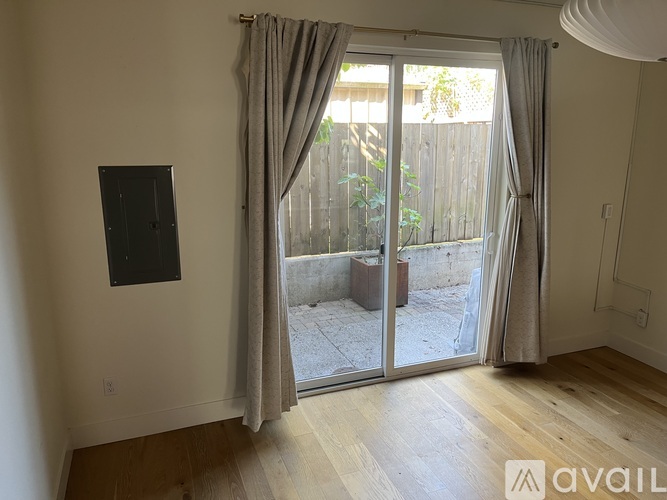 A room with a sliding glass door leading to a backyard.