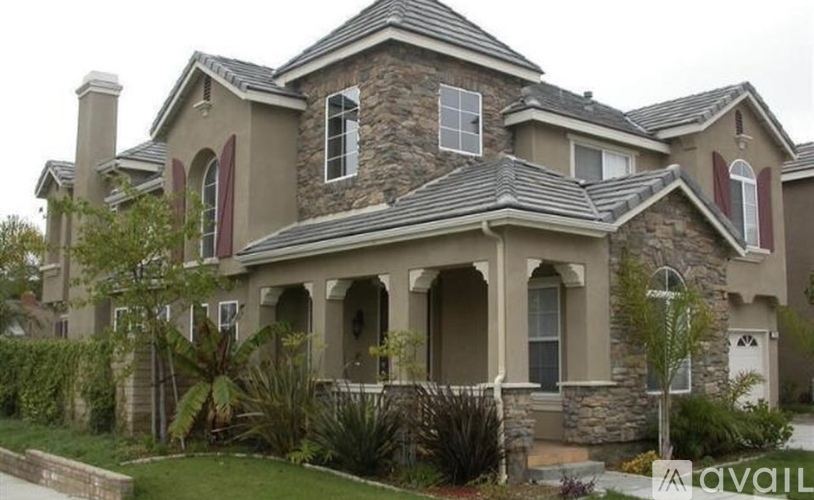 A large house with a stone wall and arched windows.