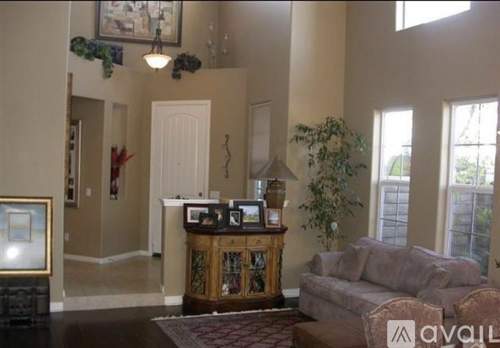 A living room with a couch, a cabinet, and a painting on the wall.
