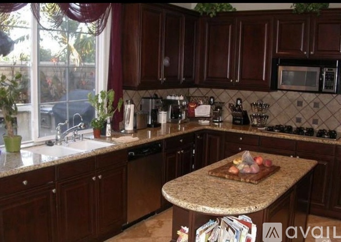 A kitchen with brown cabinets and a granite countertop.