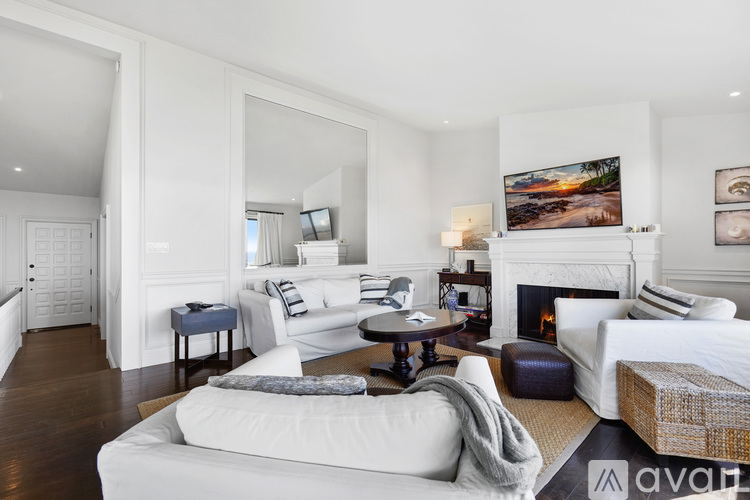 A living room with a white couch and a fireplace.