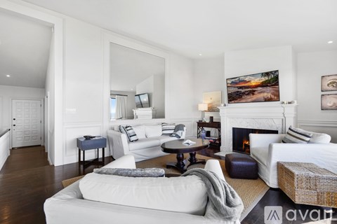 A living room with a white couch and a fireplace.