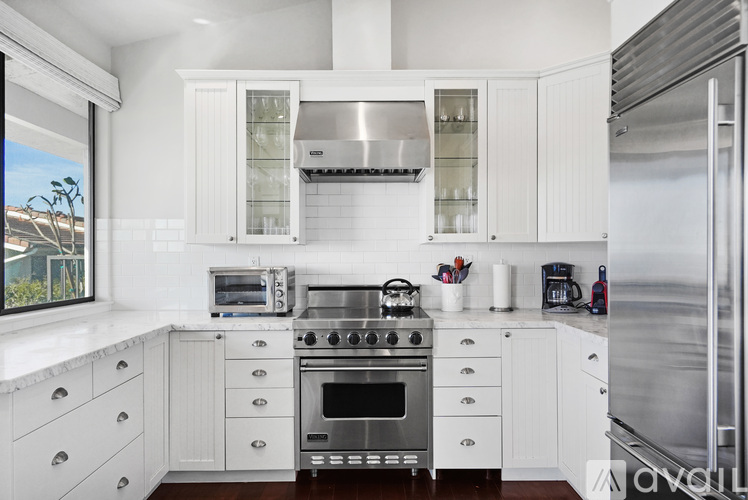 A kitchen with white cabinets and stainless steel appliances.