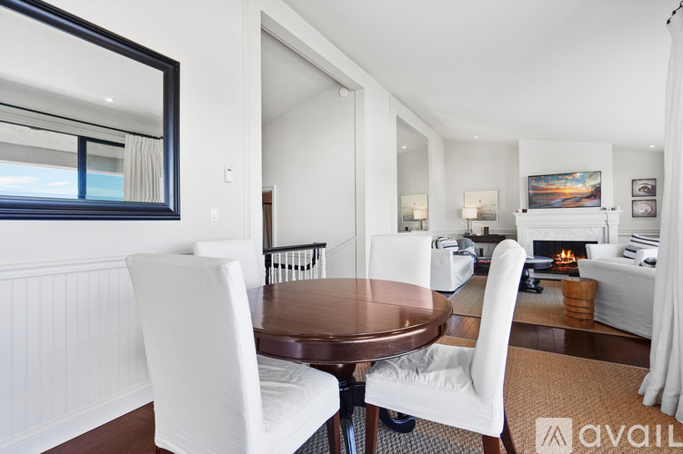 A modern dining room with a round table and white chairs.