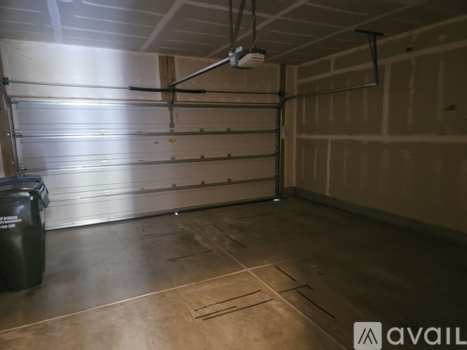 A spacious garage with a closed metal door and a fan on the ceiling.