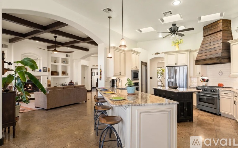 A spacious kitchen with a large island and a dining area with a table and chairs.