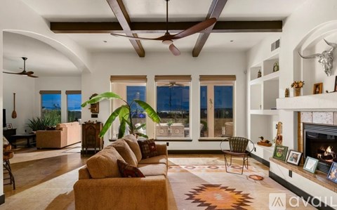 A living room with a brown couch and a fireplace.