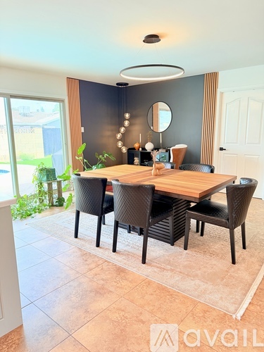 A dining room with a wooden table and chairs.