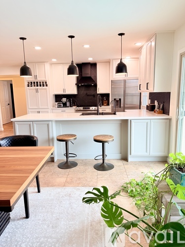 A kitchen with a white cabinetry and a black stove top.
