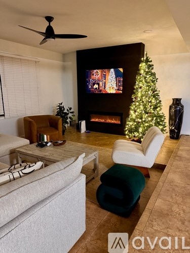 A living room with a Christmas tree and a television playing a Christmas movie.