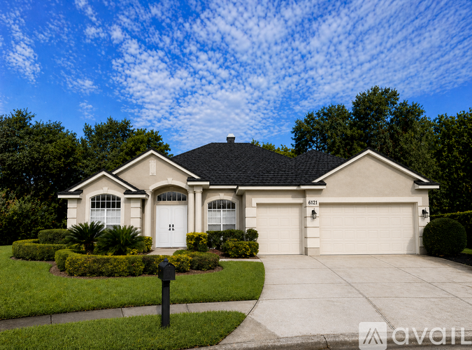A house with a white garage door and a black roof.