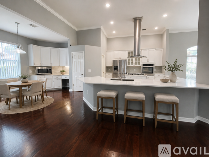 A modern kitchen with a large island and a dining table.