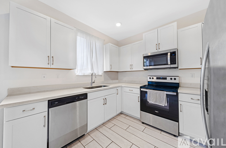 A kitchen with white cabinets and appliances.