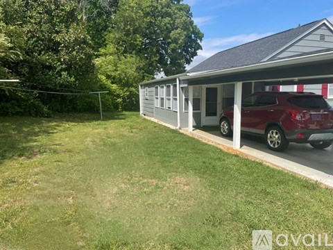 A red car is parked in front of a house.