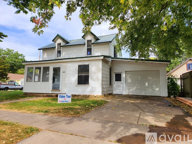 A house with a sign that says "Video Tour Available" in front of it.
