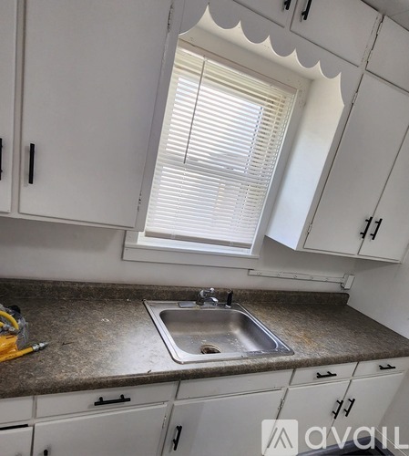 A kitchen with white cabinets and a granite countertop.