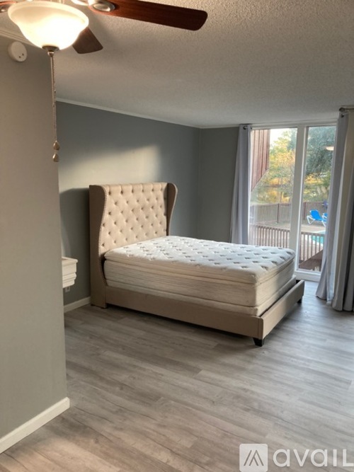 A bedroom with a large bed and a ceiling fan.