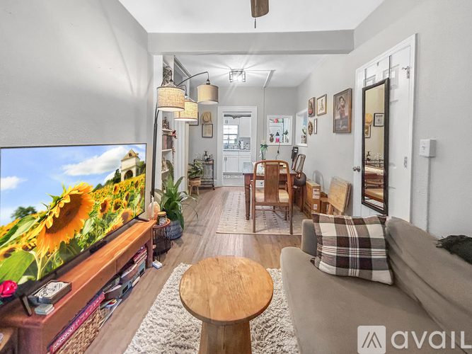 A living room with a flat screen TV and a sunflower on the screen.