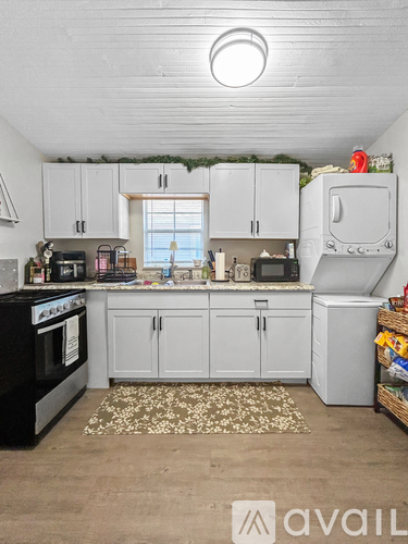 A kitchen with white cabinets and a black oven.