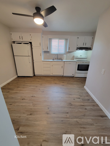 A kitchen with wooden floors and white appliances.