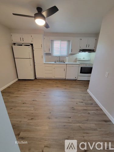 A kitchen with wooden floors and white appliances.