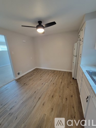 A room with wooden flooring and a ceiling fan.